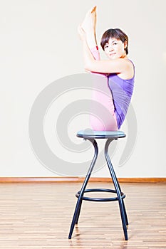 Asian woman doing exercise or yoga at home at chair