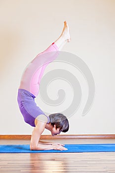 Asian woman doing exercise of yoga at mat