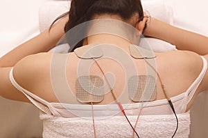 Asian woman is doing massage of electrical -stimulation ( TENs ) photo