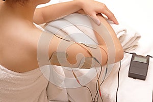 Asian woman is doing massage of electrical -stimulation ( TENs )