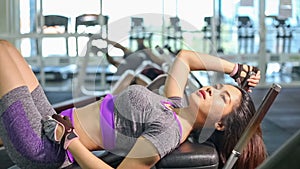 Asian woman doing sit ups fitness exercise at gym
