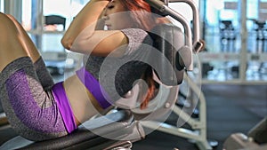 Asian woman doing sit ups fitness exercise at gym