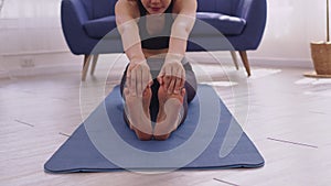 Asian woman doing stretching arms and legs muscles on yoga mat.Do fitness activity and arms stretch