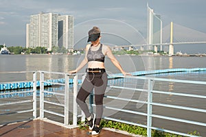 asian woman doing stretching exercises outdoors along city sidewalk