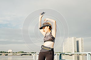 asian woman doing stretching exercises outdoors along city sidewalk