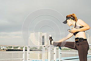 asian woman doing stretching exercises outdoors along city sidewalk in summer warm light