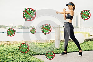 Asian woman doing stretching exercises outdoors along city sidewalk in summer warm light