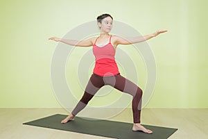 Asian woman doing warrior pose yoga.