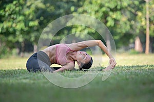 Asian woman doing yoga exercise and relax with sportswear in park, sport and healthy lifestyle concept