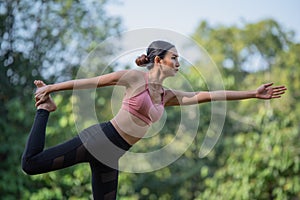 Asian woman doing yoga exercise and relax with sportswear in park, sport and healthy lifestyle concept