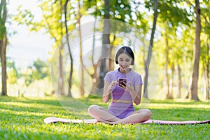 Asian woman doing yoga posing on mat in outdoor park Young healthy woman yoga exercise,