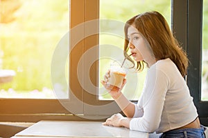 Asian woman drinking cold coffee