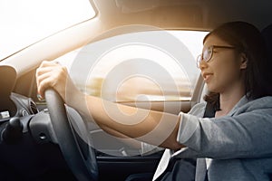 Asian woman driving a car.