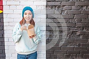 Asian woman eaiting takeaway noodles with chopsticks. Chinese fast food concept