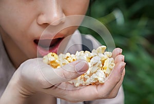 Asian woman easting popcorn full hand closed up
