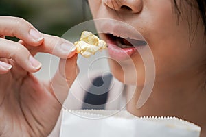 Asian woman easting popcorn full hand closed up