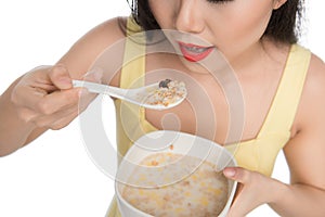 Asian woman eating bowl of cereal or muesli for breakfast