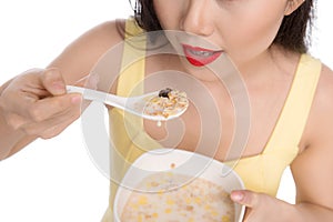 Asian woman eating bowl of cereal or muesli for breakfast