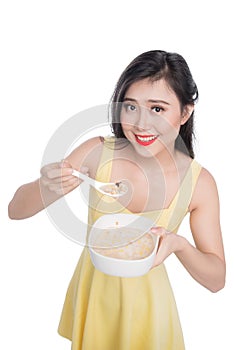 Asian woman eating bowl of cereal or muesli for breakfast