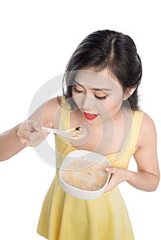 Asian woman eating bowl of cereal or muesli for breakfast