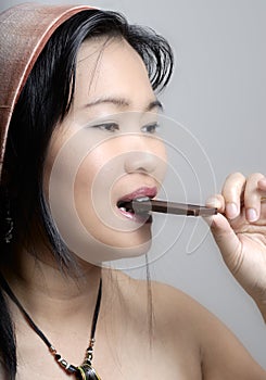 Asian woman eating a chocolate bar