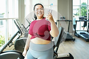 Asian woman eating healthy fresh water before fitness exercise for lose weight. photo