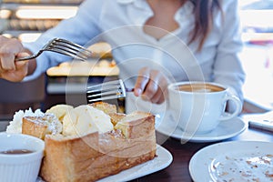 Asian woman are eating ice ream and delicious bread.Focus on for