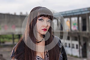 Asian woman in emo goth clothes at an abandoned building