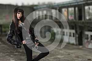 Asian woman in emo goth clothes at an abandoned building