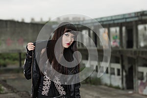 Asian woman in emo goth clothes at an abandoned building