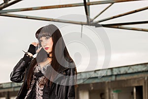 Asian woman in emo goth clothes at an abandoned building