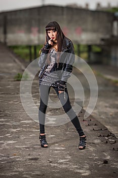 Asian woman in emo goth clothes at an abandoned building