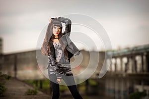 Asian woman in emo goth clothes at an abandoned building