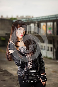 Asian woman in emo goth clothes at an abandoned building