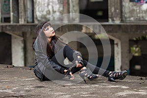 Asian woman in emo goth clothes at an abandoned building