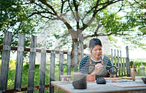 Asian woman is engaged in pottery making and clay painting activities