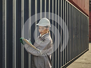 Asian woman engineer working in container port terminal