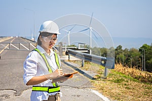 Asian woman engineers are checking and submitting reports outdoors on site power plant energy