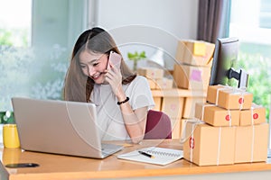 Asian woman enjoy herself while using  internet on laptop and phone in office. Business and marketing and part time concept.