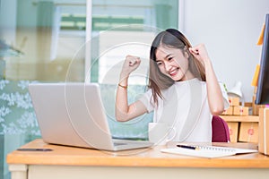 Asian woman enjoy herself while using laptops and internet in office. Business and marketing and part time concept. On line