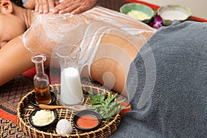 Asian woman enjoying a salt scrub massage at spa