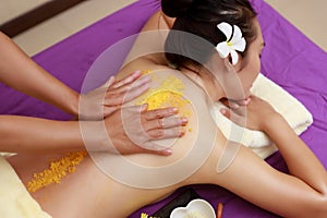 Asian woman enjoying a salt scrub massage at spa