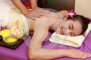 Asian woman enjoying a salt scrub massage at spa