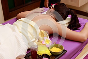 Asian woman enjoying a salt scrub massage at spa