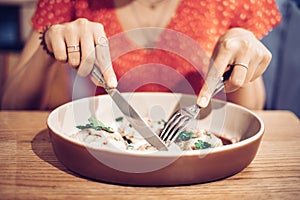 Asian woman enthusiastically eats a delicious dish in a Haute cuisine restaurant