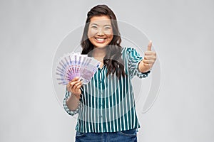 Asian woman with euro money showing thumbs up