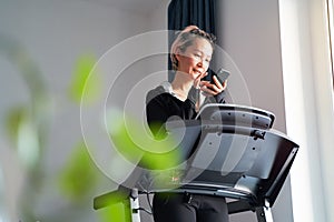 Asian woman exercising on treadmill home gym