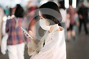 Asian woman with face mask and smartphone