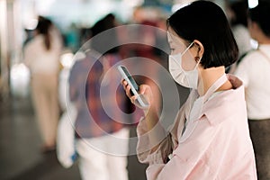 Asian woman with face mask and smartphone