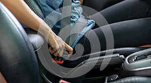 Asian woman fastening seat belt in the car, safety concept